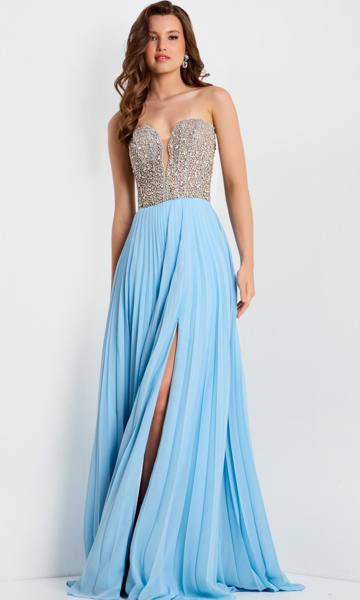 A woman wears the Jovani 44358 long prom dress in light-blue, featuring a strapless beaded bodice, chiffon A-line skirt, and a dramatic high slit.